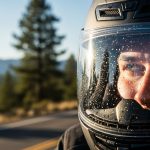 Close-up of a focused motorcycle rider's eyes behind a helmet visor, looking ahead on a mountain road